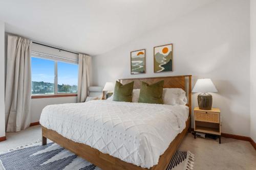 a bedroom with a bed and a large window at LakeView Queen Anne 3BR Townhome in Seattle