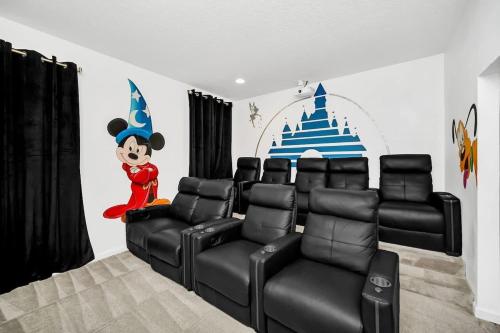 a room with chairs and a mickey mouse wall at EPIC 12 Bedroom Home with Private Pool in Kissimmee