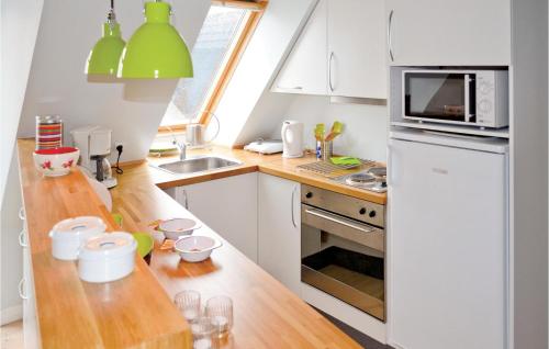 a kitchen with white cabinets and a wooden counter top at Apartment Nytorv in Ebeltoft