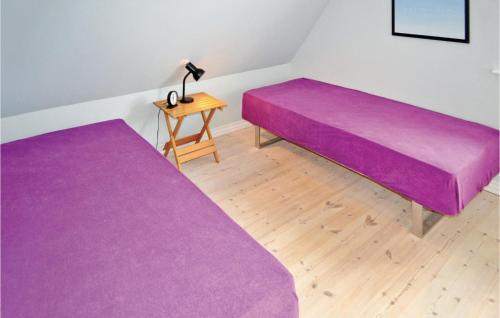 two purple beds in a room with a table at Apartment Nytorv in Ebeltoft