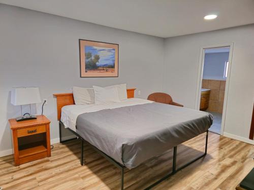 a bedroom with a bed and a table with a lamp at The L Motel Downtown/NAU Conference Center in Flagstaff