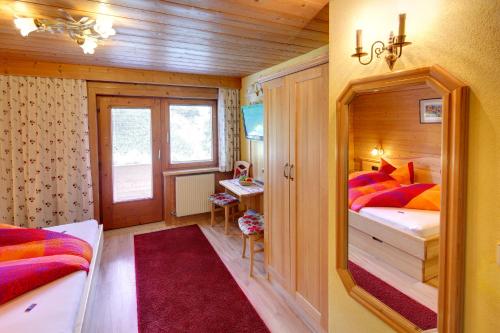 a bedroom with two beds and a red rug at Haus Seebach in Berwang