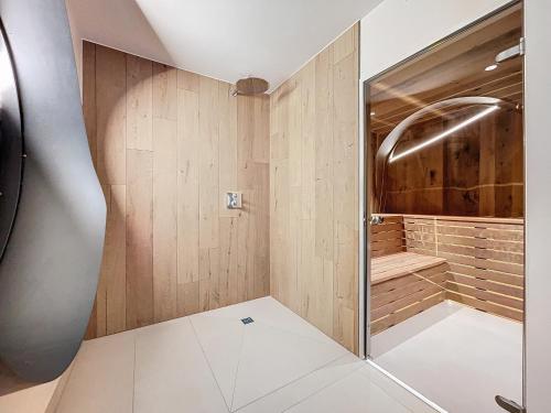 La salle de bains est pourvue d'une douche et de murs en bois. dans l'établissement Chalet Alto - Morzine - Proche Centre, à Morzine