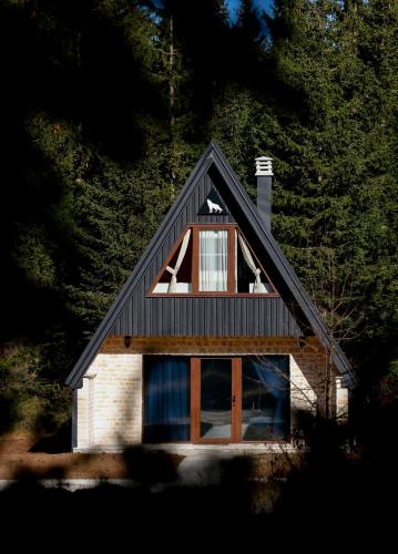 a house with a gambrel roof and windows at Wild Lodges in Žabljak