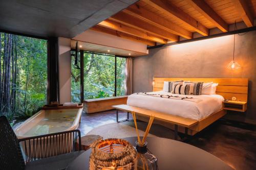 a bedroom with a bed and a tub in it at Casa Chichipicas Hotel Boutique in Valle de Bravo