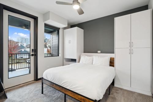 a bedroom with a white bed and a window at CozySuites Mass with parking lounge & roof deck #23 in Indianapolis