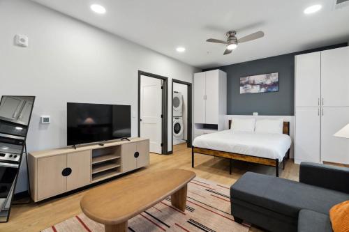 a large living room with a bed and a television at CozySuites Mass with parking lounge & roof deck #24 in Indianapolis