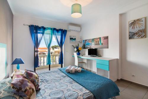 a bedroom with a bed and a desk and a window at Apartamentos Paradise Fuseta in Fuzeta