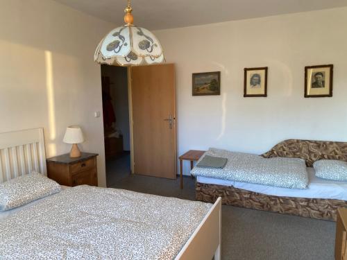 a bedroom with two beds and a chandelier at Apartmán Pod Studenou Horou in Rokytnice nad Jizerou