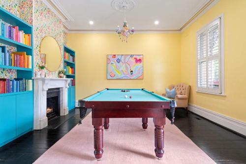 a room with a pool table and a fireplace at The Evelyn in Melbourne