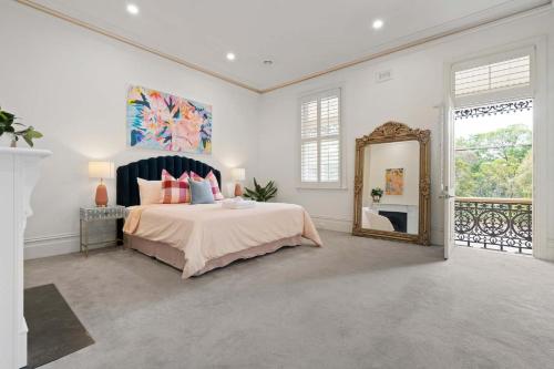 a bedroom with a large bed and a mirror at The Evelyn in Melbourne