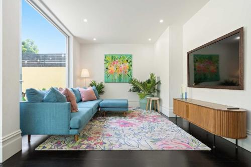 a living room with a blue couch and a tv at The Evelyn in Melbourne