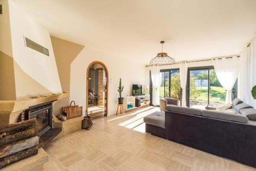 un salon avec un canapé et une cheminée dans l'établissement Maison spacieuse vue sur mer a Pleubian, à Pleubian