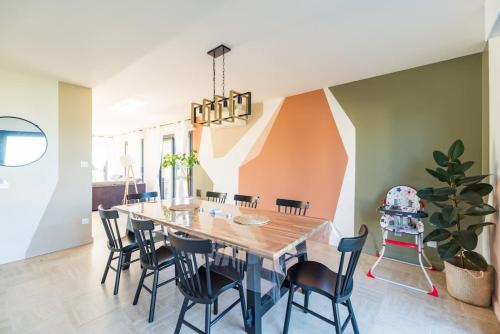une salle à manger avec une table et des chaises en bois dans l'établissement Maison spacieuse vue sur mer a Pleubian, à Pleubian
