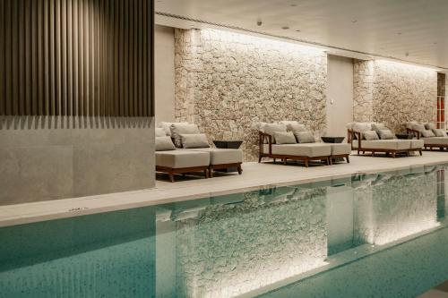 a pool with chaise lounge chairs and a swimming pool at Hyatt Centric Malta in St. Julianʼs