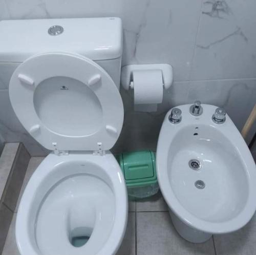 a bathroom with a white toilet and a sink at Alojamiento Loft céntrico in Esperanza