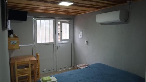 a bedroom with a bed and a door and a table at Alojamiento Loft céntrico in Esperanza