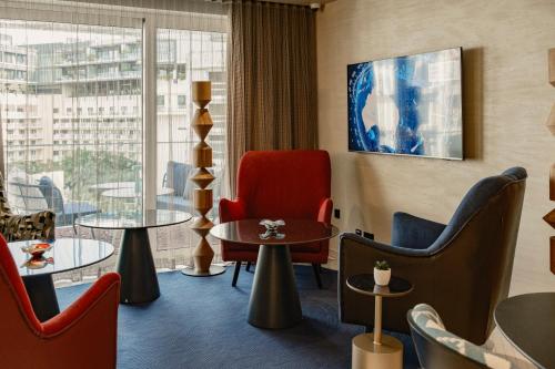 a hotel room with chairs and tables and a window at Hyatt Centric Malta in St. Julianʼs