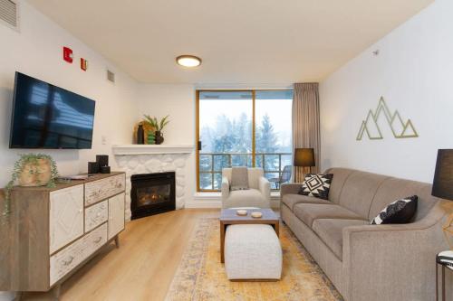 a living room with a couch and a tv at Renovated 1Bed-1Bath in Village with Pool, Hot Tub, and Sauna in Whistler