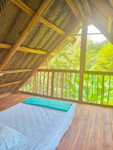a bed in a room with a roof at Frana Lodge in El Zaino