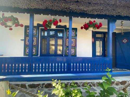 a blue bench in front of a house with flowers at Casa Soarelui in Murighiol