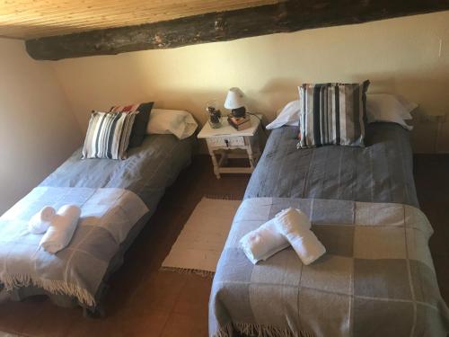 two beds sitting next to each other in a room at Casa Sierra de Gredos in Navasequilla