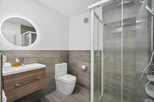 a bathroom with a toilet and a glass shower at Mt Iron Vista in Wanaka