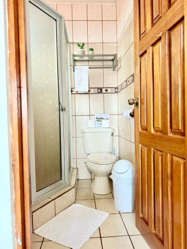 a bathroom with a toilet and a glass door at Sweet Home Carrión in Fortuna