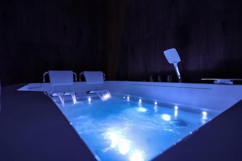 - un bain à remous avec des lumières dans une pièce avec des chaises dans l'établissement Spa Appartement Jacuzzi Privé Strasbourg, à Strasbourg