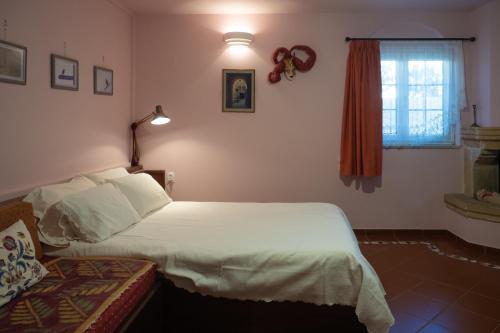 a bedroom with a white bed and a window at Private Art Studio 50m from sea (1-4 per) in Monemvasia