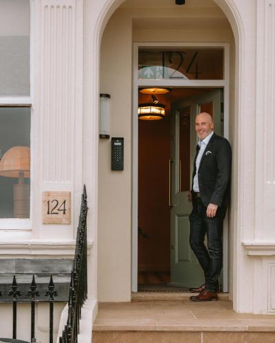 a man standing in the doorway of a building at No.124 by GuestHouse, Brighton in Brighton & Hove