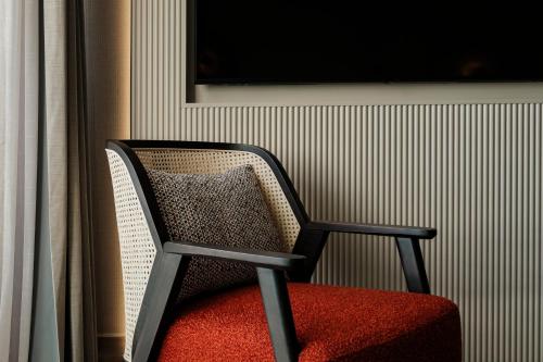 a black and red chair with a red cushion at Hyatt Centric Malta in St. Julianʼs