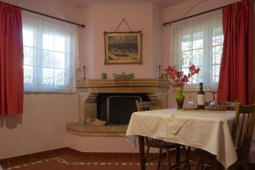 a dining room with a table and a fireplace at Private Art Studio 50m from sea (1-4 per) in Monemvasia