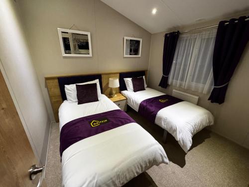 two beds in a small room at Meadows 33 Hot tub - Southview Holiday Park in Skegness