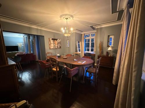 une salle à manger avec une table et des chaises en bois dans l'établissement Demeure de charme - 10 min plage - Golf 4km - Lac Caniel 1km, à Clasville