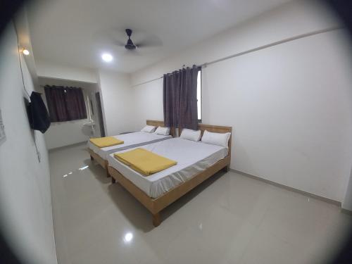 a bedroom with a bed in a white room at Hotel Highway Palace in Nashik