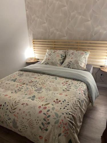 - une chambre dotée d'un lit avec une couverture et des oreillers dans l'établissement Chez Lyseha et André, à Saint-Claude