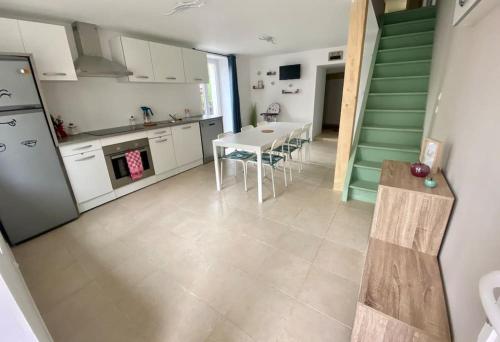 une cuisine avec une table et des chaises dans une pièce dans l'établissement Chez Lyseha et André, à Saint-Claude