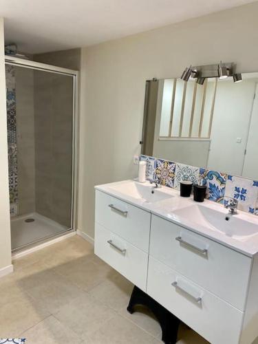 une salle de bain avec deux lavabos et une douche dans l'établissement Chez Lyseha et André, à Saint-Claude