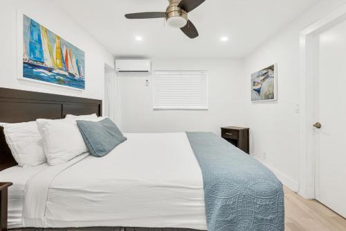 a bedroom with a white bed and a ceiling fan at ULTRA spacious apartment steps from the beach in Hollywood
