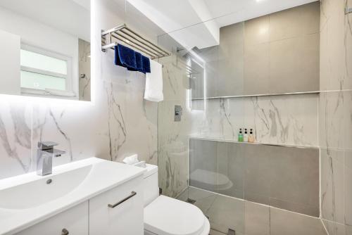 a white bathroom with a toilet and a sink at ULTRA spacious apartment steps from the beach in Hollywood