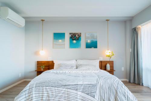 a bedroom with a large bed with white sheets at Panoramic Oceanview Resort - Full Kitchen in Each Unit, 2 Swimming Pools, Onsite Restaurants, Fireworks Every Friday in Honolulu