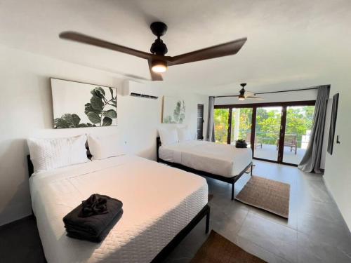 a bedroom with two beds and a ceiling fan at Yunque Reserve Secluded Rainforest House in Hato Candal