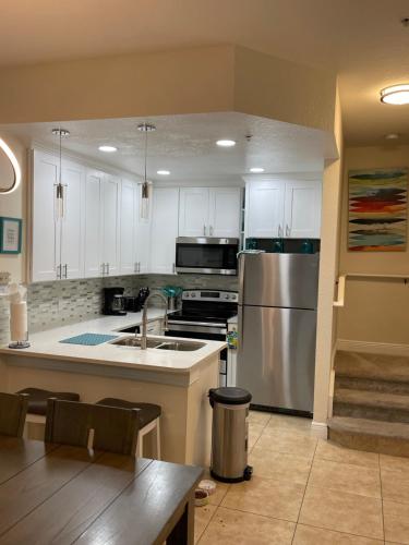 Una cocina con gabinetes blancos y un refrigerador de acero inoxidable. en Venetian Bay Villages, en Kissimmee