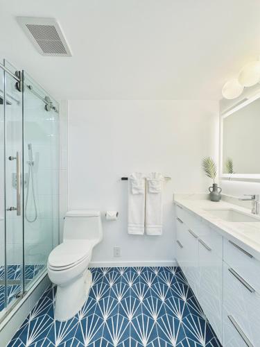 a white bathroom with a toilet and a sink at Panoramic Oceanview Resort - Full Kitchen in Each Unit, 2 Swimming Pools, Onsite Restaurants, Fireworks Every Friday in Honolulu