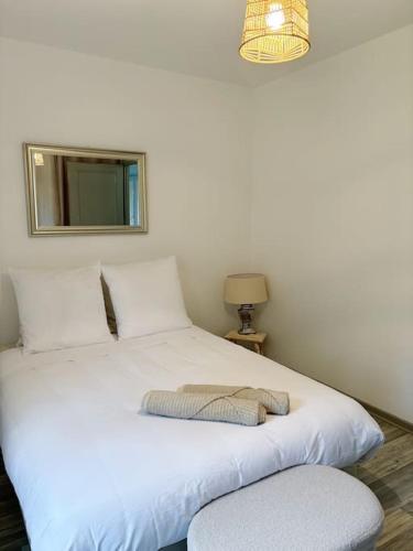 une chambre avec deux lits et un miroir au mur dans l'établissement La petite Luss, à Colmar