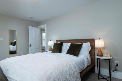 a bedroom with a large white bed with green pillows at Updated Family-sized Home in Heart of Rutland, Near Slopes, EV Level 2, Hot Tub in Rutland