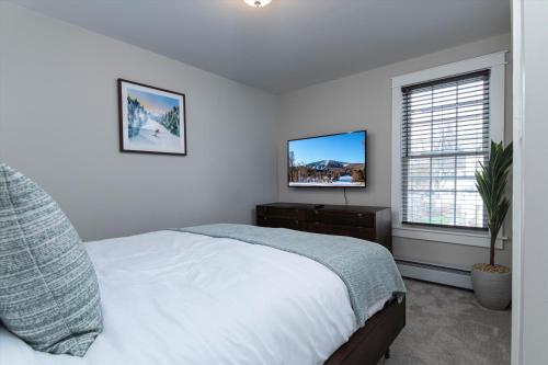 a white bedroom with a bed and a window at Updated Family-sized Home in Heart of Rutland, Near Slopes, EV Level 2, Hot Tub in Rutland