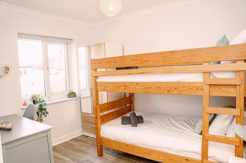 a bedroom with two bunk beds and a desk at Pass the Keys Dungeness Drift - By the Beach in Folkestone