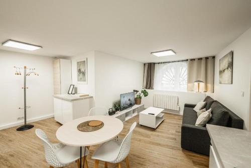 un salon avec une table, des chaises et un canapé dans l'établissement Appartement rénové place du Palais avec parking, à Bordeaux